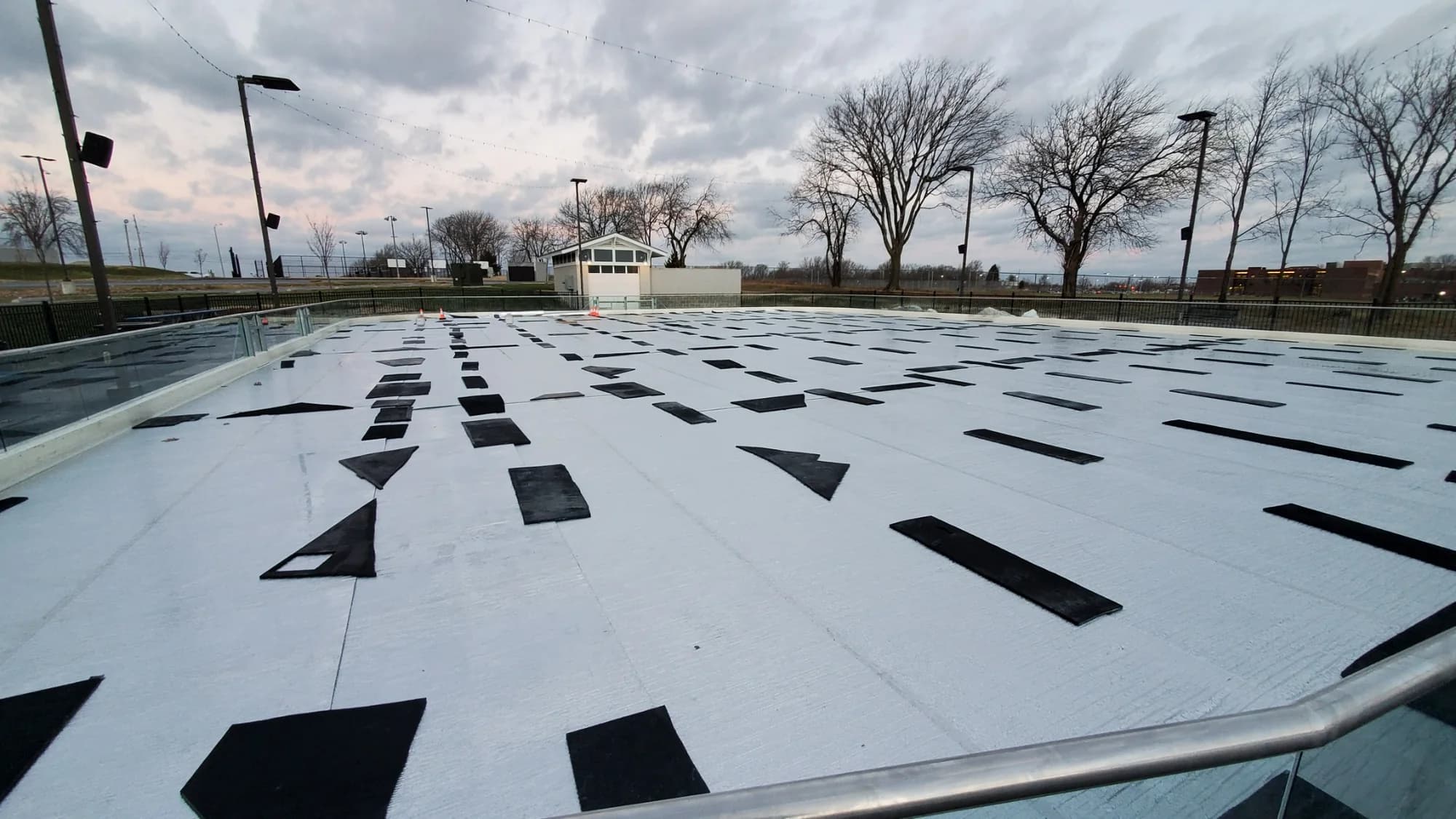 Full-rink reflective ice protection blanket installed under overcast conditions